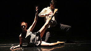 Eine Ballerina und ein Tänzer tanzen auf einer Bühne.