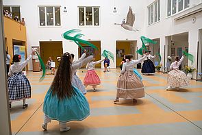 Kinder tanzen im Foyer der Schule.