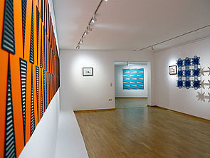 Ein Ausstellungsraum. An der Wand hängen Bilder von Stine Albrecht.