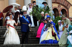 Frauen und Männer stehen in historischen Kostümen auf einer Treppe.
