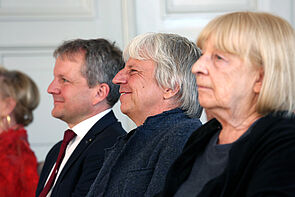 Porträtaufnahme von drei Personen. Eine Frau, zwei Männer.