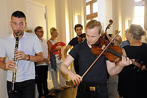 Musiker spielen auf den Fluren ihre Instrumente.