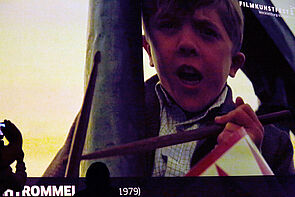 Ein Filmausschnitt wird gezeigt. Zu sehen ist ein Junge mit Blechtrommel.