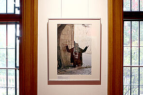 Ein Bild aus der Ausstellung. Es zeigt einen betenden Mann.