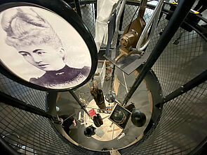 An manchen Stellen befinden sich große Löcher im Boden. Gestelle mit Exponaten führen durch sie hindurch und verbinden die beiden Etagen des Museums miteinander.