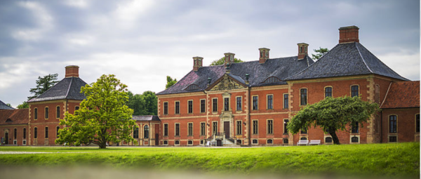 Vor dem Schloss Bothmer blühen Bäume und wächst Gras.