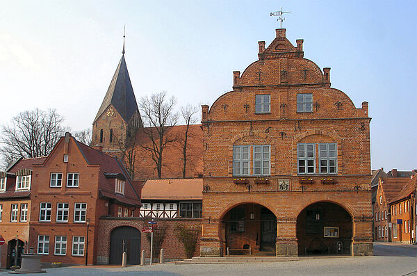 Ein Backsteinhaus von außen. Das Haus hat große Fenster und Torbögen. Das Haus ist das Rathaus von Gadebusch. 