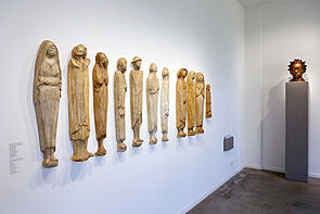 Elf Figuren hängen an der Wand.