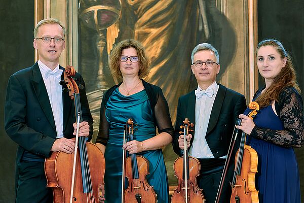Gruppenbild. Zwei Musikerinnen und zwei Musiker schauen in die Kamera.