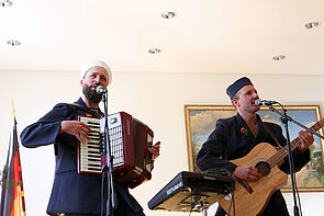 Zwei Musiker spielen vor Publikum. 