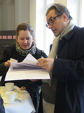 Ein Mann und eine Frau schauen gemeinsam in die Unterlagen zur Kulturkonferenz.
