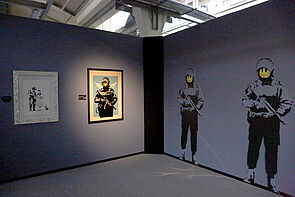 Bewaffnete Smiley-Figuren. Ein Banksy-Motiv.