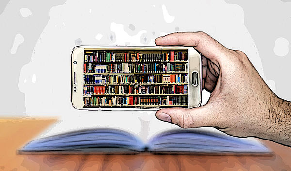 Eine Hand hält ein Handy. Auf dem Display reihen sich viele Bücher in einem Regal aneinander. Im Hintergrund liegt ein aufgeschlagenes Buch.