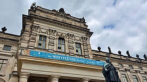 Ein Banner hängt am Schloss und kündigt die Eröffnung an.