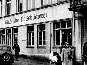 Schwarz-Weiß-Aufnahme einer Hausfassade. Darauf steht "Volksbücherei". 