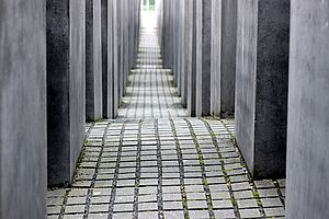 Kopfsteinpflaster an Kopfsteinpflaster. Darauf stehen Betonstelen. 