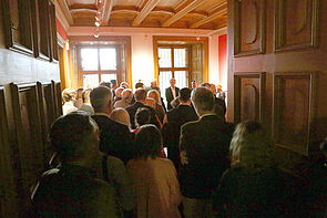 Menschen stehen dicht gedrängt in einem Raum.