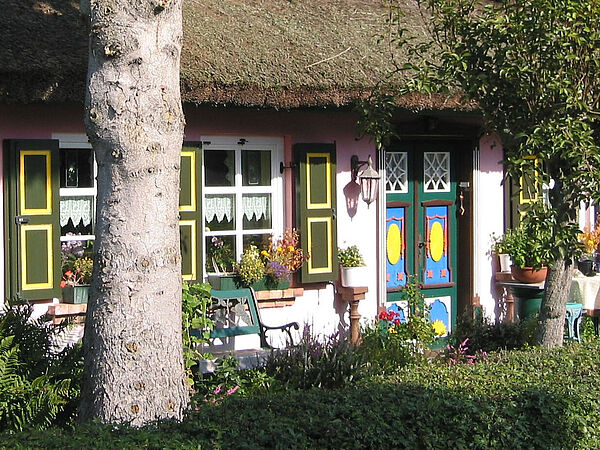 Ein restgedecktes Haus mit einer bunt verzierten Haustür.