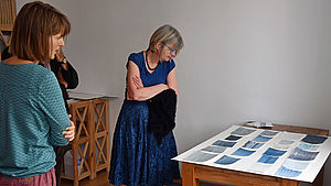 Die Künstlerin und Mitglieder der Kunstkommission betrachten Kunstwerke.