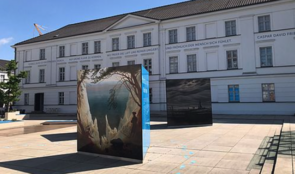 Das Pommersche Landesmuseum von außen. Ein weißes Haus, davor stehen Aufsteller für die Ausstellung.