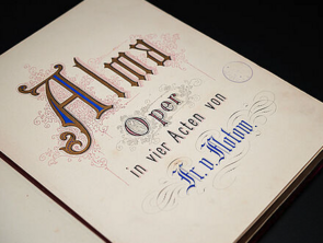 Eine aufgeschlagene Buchseite. Darauf steht: Alma. Oper in vier Akten. Fr. v. Flotow.