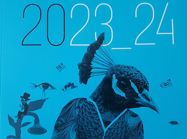 Blauer Hintergrund, darauf zu sehen: Papagino (statt Papageno). Das Cover mit dem Programm für die Spielzeit 2023/24. 
