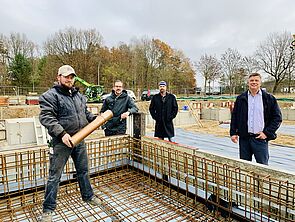 Vier Männer stehen auf einer Baustelle.