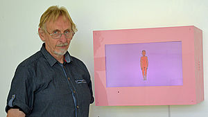 Udo Dettmann steht neben einem seiner Kunstwerke.