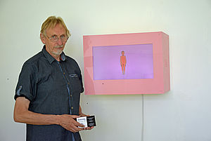 Udo Dettmann steht neben einem seiner Kunstwerke.