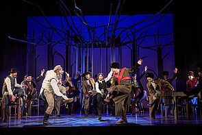 Auf einer Bühne wird gefeiert und getanzt.