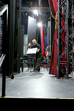 Ein Mann winkt in die Kamera.