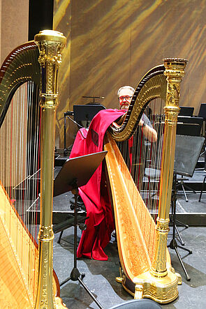 Ein Mann verpackt die Harfe nach der Probe.