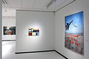 Drei Bilder hängen an den weißen Wänden.