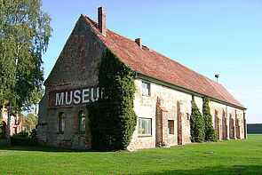 Ein Backsteingebäude. An der Fassade steht in großen Buchstaben das Wort Museum.