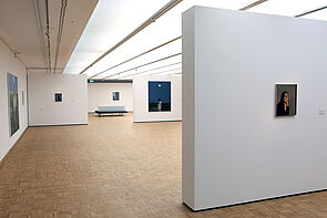 Ein Blick in die Ausstellung. Vereinzelt hängen Bilder an weißen Wänden.
