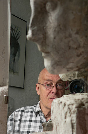 Wilfried Schröder steht hinter eine Skulptur.