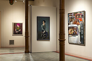 Drei moderne Kunstwerke hängen in einem Ausstellungsraum.