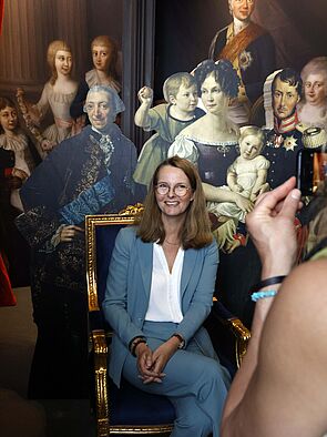 Eine Frau sitzt auf einem Stuhl und wird fotografiert.