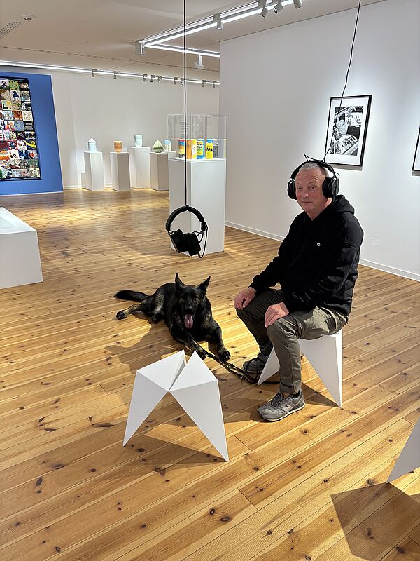 Ein Mann und sein Hund besuchen die Kunsthalle Rostock.