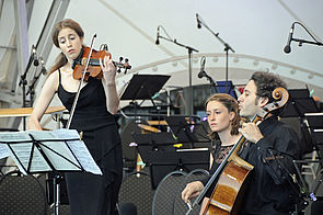 Vilde Frang steht mit ihrer Violine vor einem Notenständer und spielt. Neben ihr sitzt Nicolas Altstaedt mit seinem Violonchello.