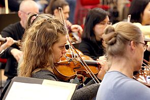 Eine Musikerin spielt auf ihrer Geige.