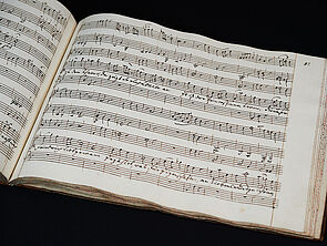 Ein aufgeschlagenes Buch. Auf der Seite die Noten eines Musikstücks.