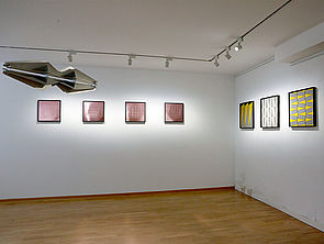 An der Wand hängen Bilder von Stine Albrecht. Vier links, drei rechts.
