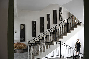 Ein Treppenhaus mit Kunstwerken an der Wand.