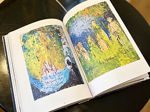 Ein aufgeschlagenes Buch. Darin zu sehen: zwei Bilder.