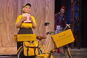 Eine als Postbotin verkleidete Schauspielerin.