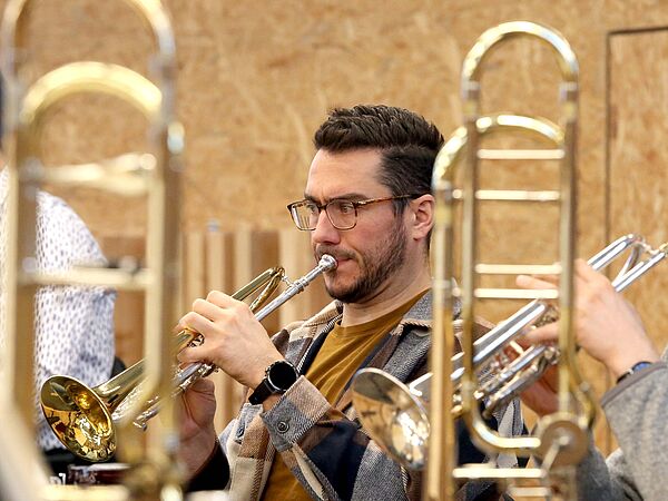 Zwei Musiker proben mit der Trompete.