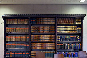 Eine Bücherwand mit historischen Werken.