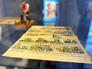 In einer Vitrine liegt eine Comic-Seite aus der Frösi.