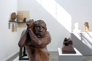 Ein Kunstobjekt. Eine Figur hält die Hände seitlich am Kopf.